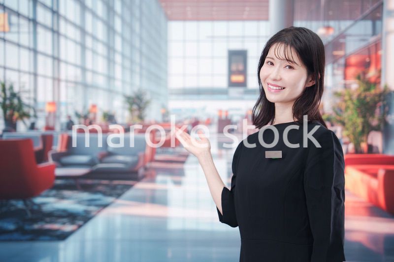 空港のラウンジで接客をする若い女性スタッフ