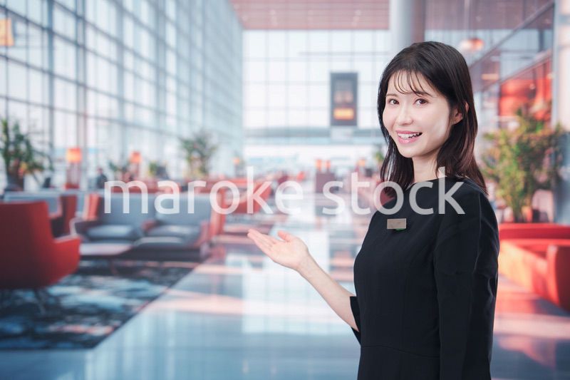 空港のラウンジで接客をする若い女性スタッフ