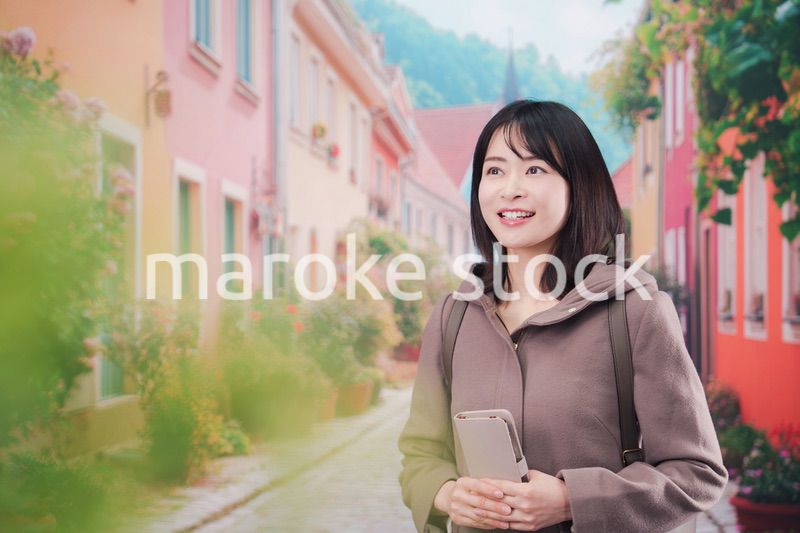 海外の街を一人で歩いて観光をする若い女性