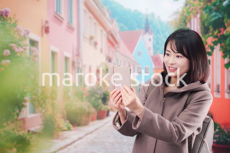 海外の街を一人で歩いて観光をする若い女性