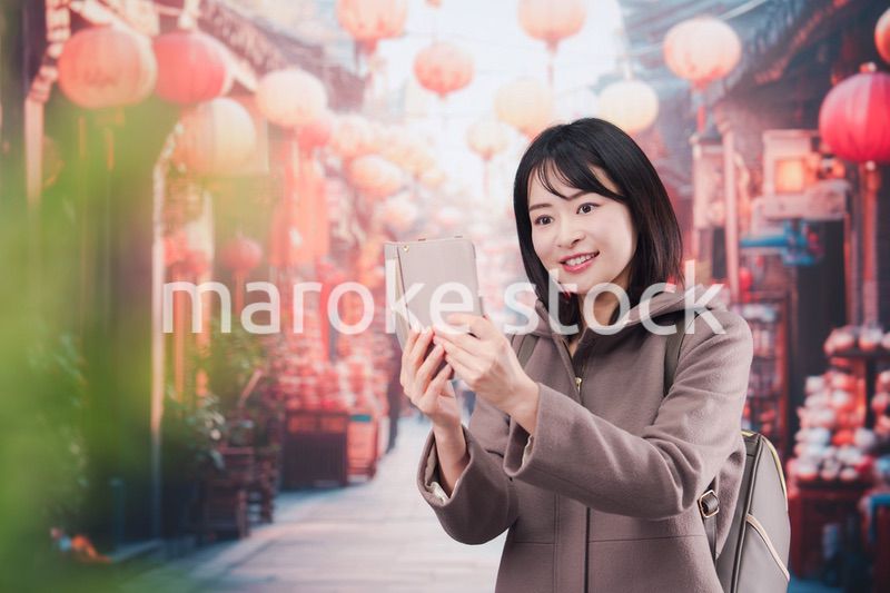 海外の街を一人で歩いて観光をする若い女性