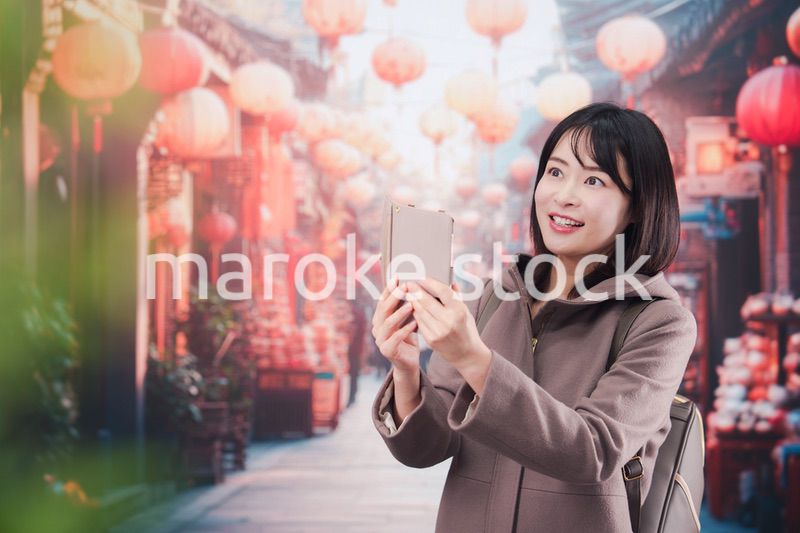 海外の街を一人で歩いて観光をする若い女性