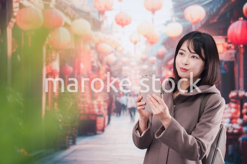 海外の街を一人で歩いて観光をする若い女性