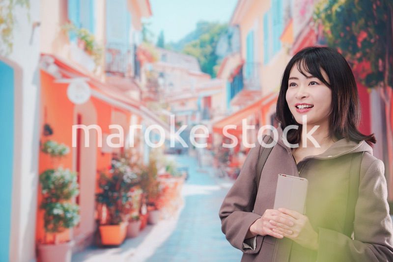 海外の街を一人で歩いて観光をする若い女性