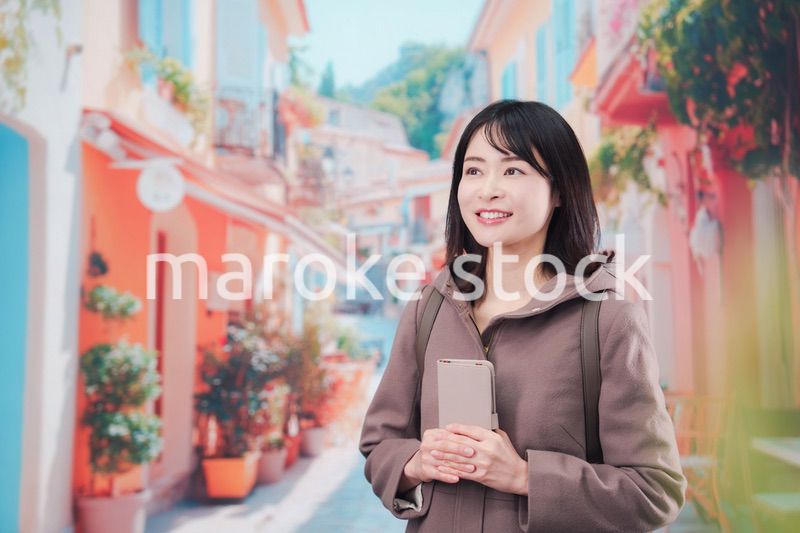 海外の街を一人で歩いて観光をする若い女性