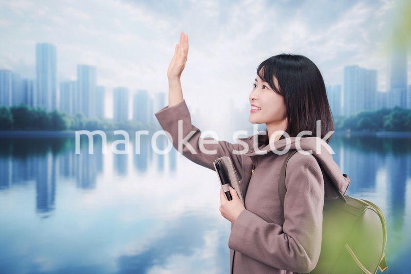 コートを着てスマホを使いながら外を歩く若い女性