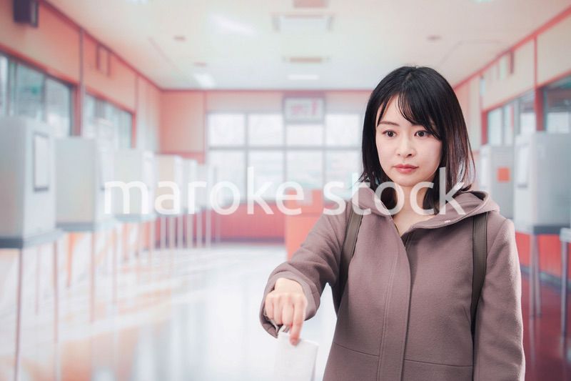 投票所で選挙の投票をする女性の有権者