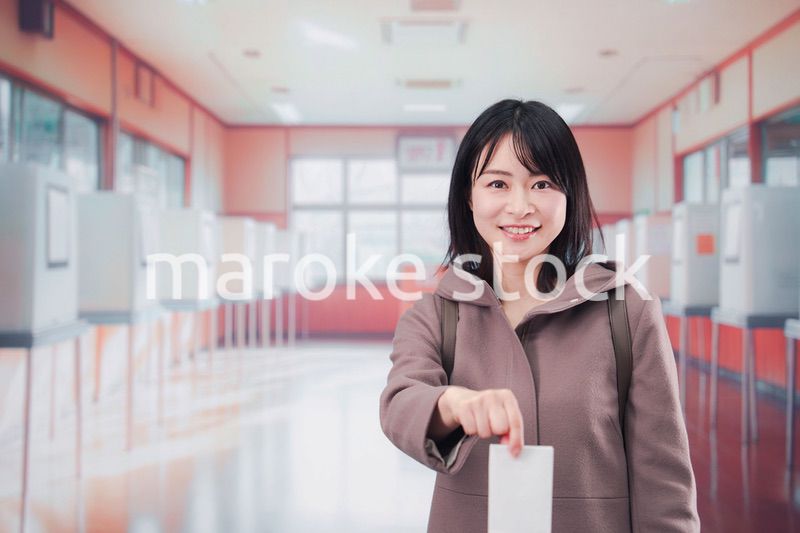 投票所で選挙の投票をする女性の有権者