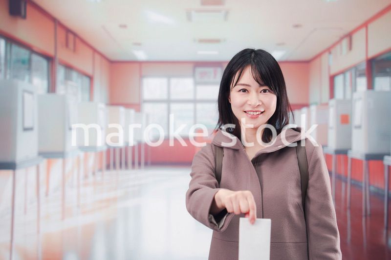 投票所で選挙の投票をする女性の有権者