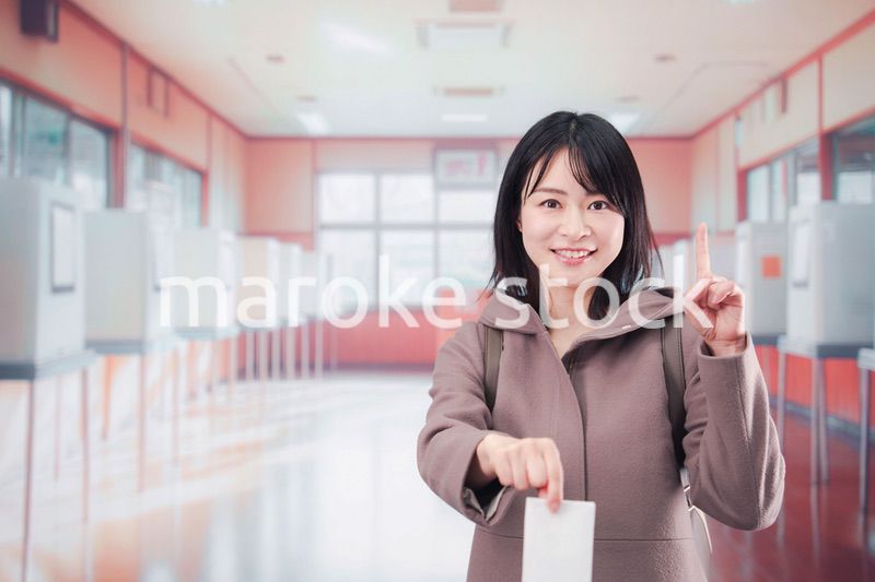 投票所で選挙の投票をする女性の有権者