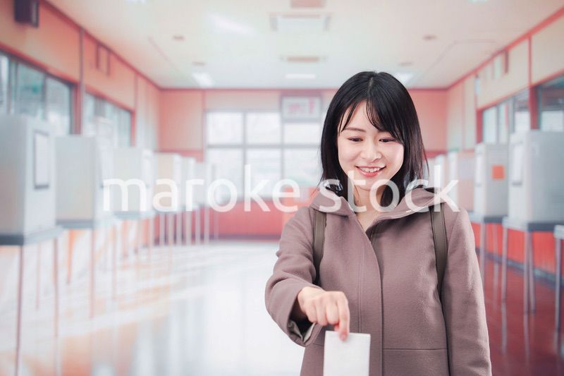 投票所で選挙の投票をする女性の有権者