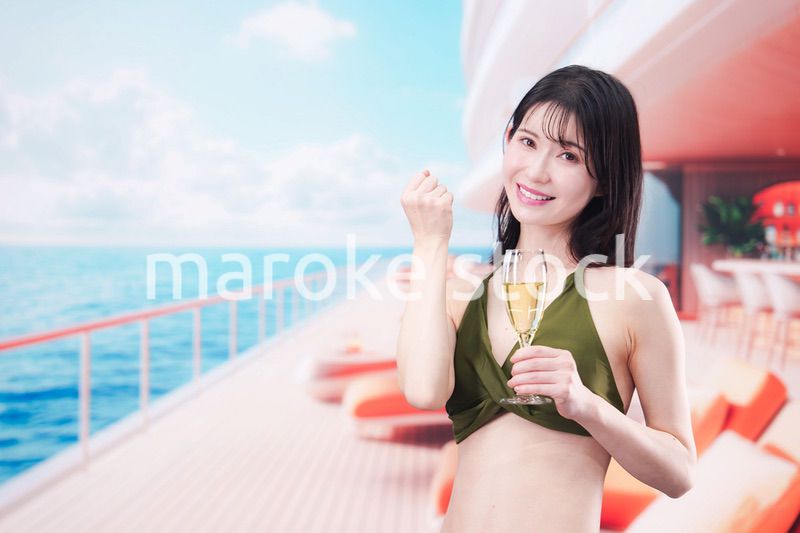 クルーズ船で水着を着てスパークリングワインを飲む若い女性