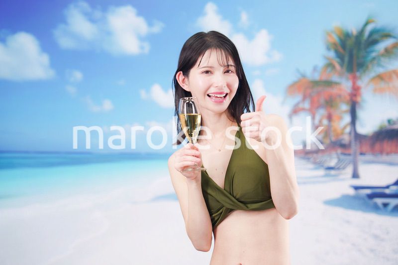 真夏のビーチでスパークリングワインを飲む水着を着た若い女性