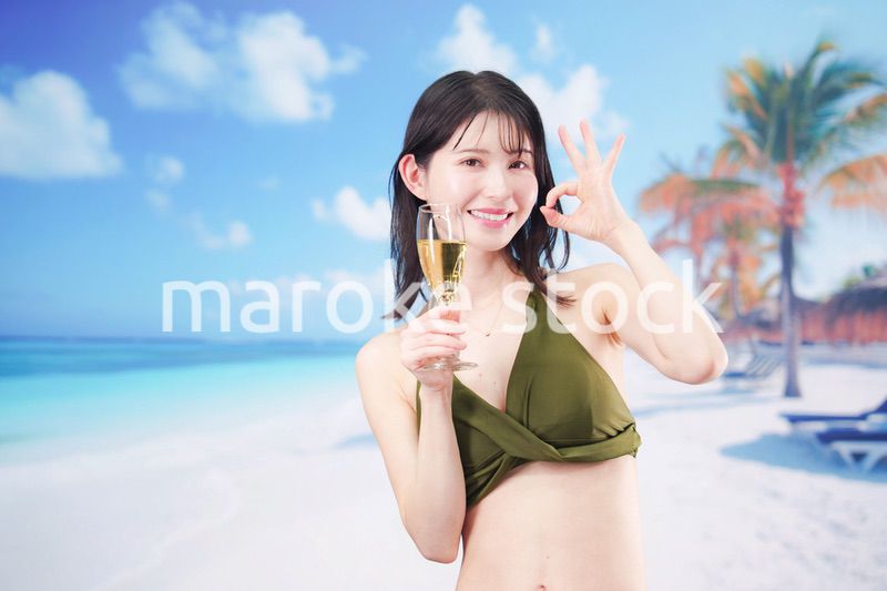 真夏のビーチでスパークリングワインを飲む水着を着た若い女性
