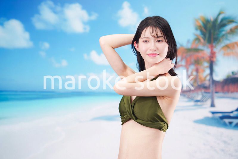 真夏のビーチでポーズを決める若い女性