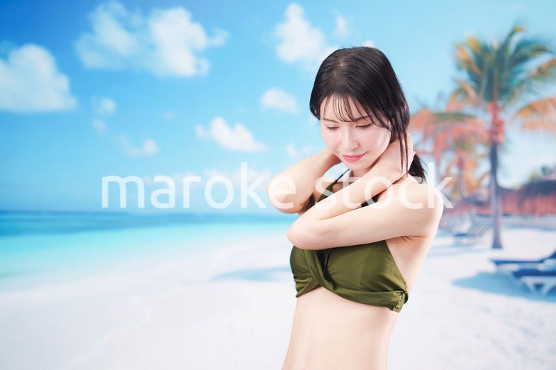 真夏のビーチでポーズを決める若い女性