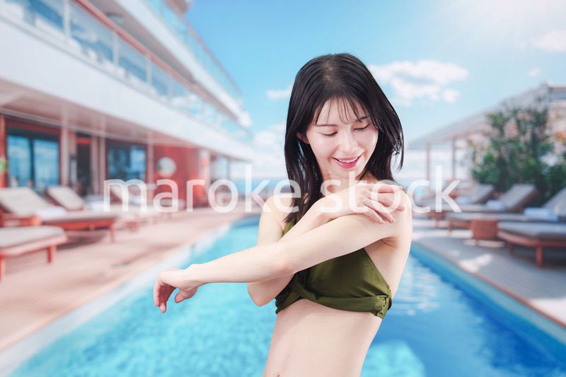 真夏のリゾートで日焼け止めクリームを塗る若い女性