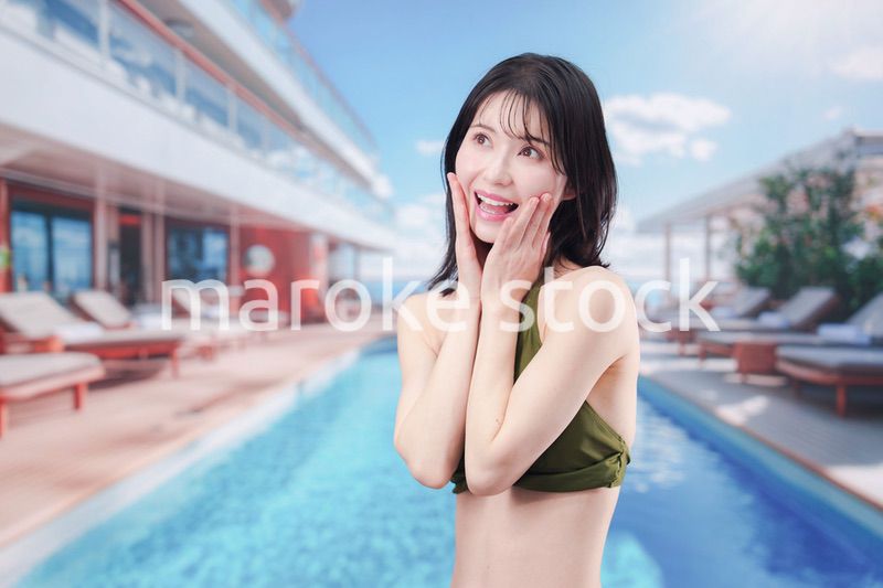 太陽が降り注ぐリゾートで顔に日焼け止めを塗る水着姿の女性