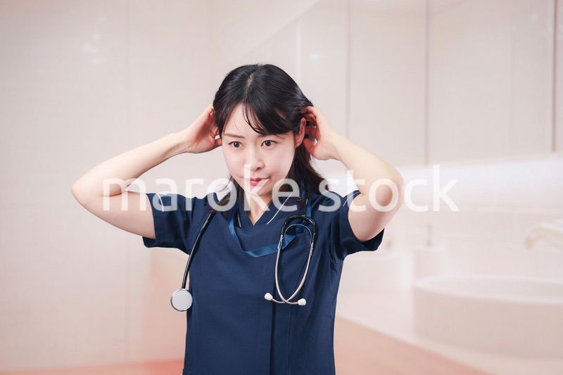 化粧室で身だしなみを整える医療従事者の女性