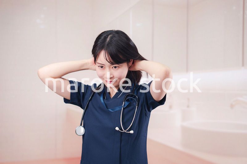 化粧室で身だしなみを整える医療従事者の女性