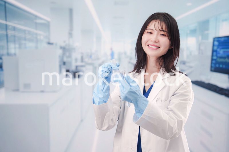 実験室で試験管の薬品を扱う若い女性