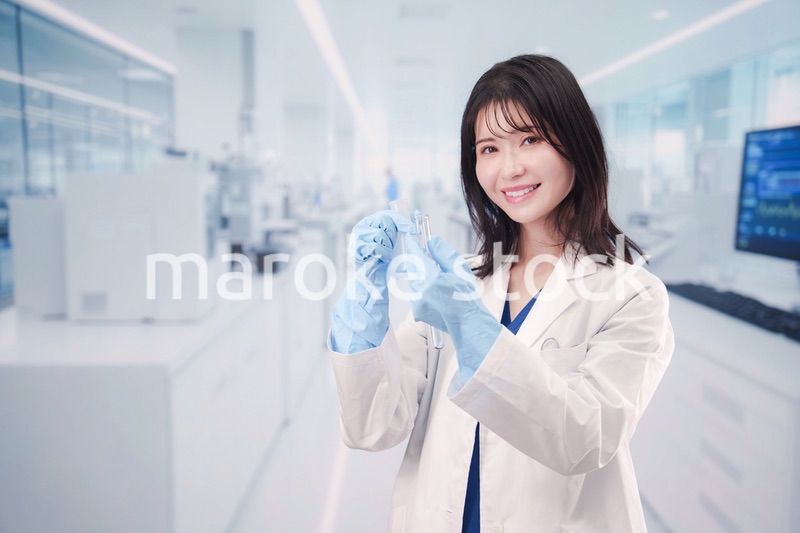 実験室で試験管の薬品を扱う若い女性