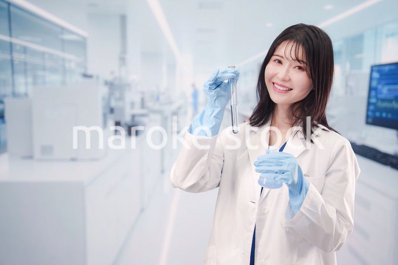 実験室で試験管の薬品を扱う若い女性