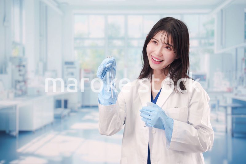 実験室で試験管の薬品を扱う若い女性