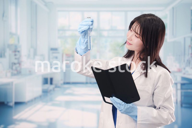 実験室で試験管の薬品を扱う若い女性