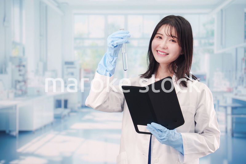 実験室で試験管の薬品を扱う若い女性
