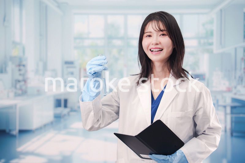 実験室で試験管の薬品を扱う若い女性