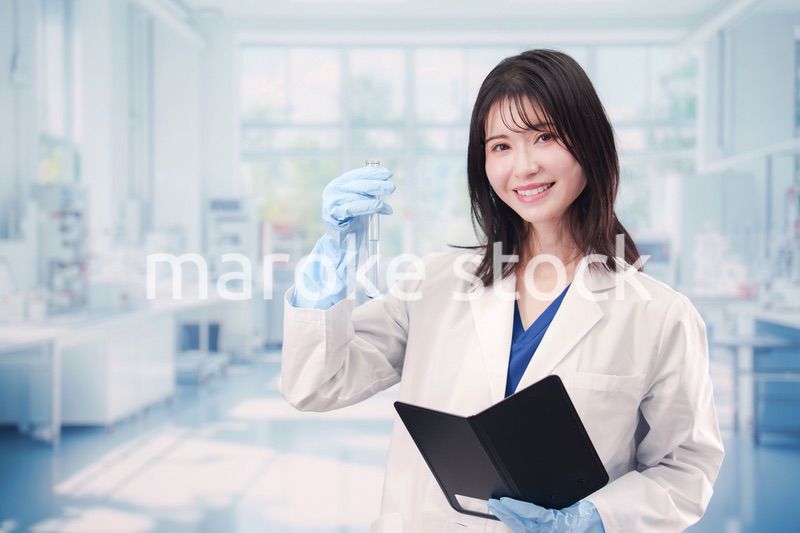 実験室で試験管の薬品を扱う若い女性