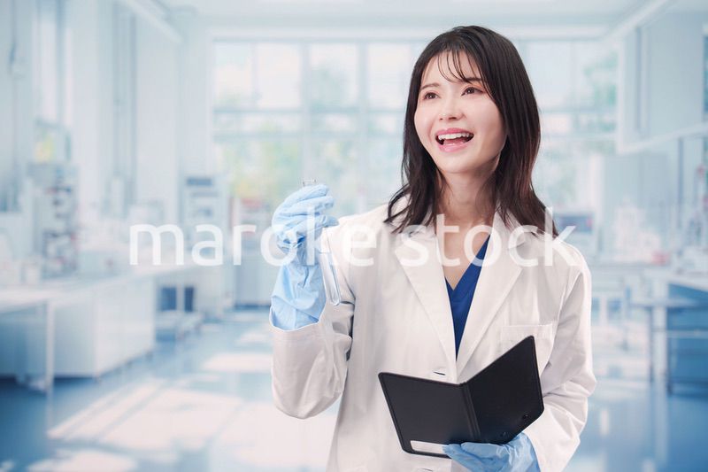 実験室で試験管の薬品を扱う若い女性