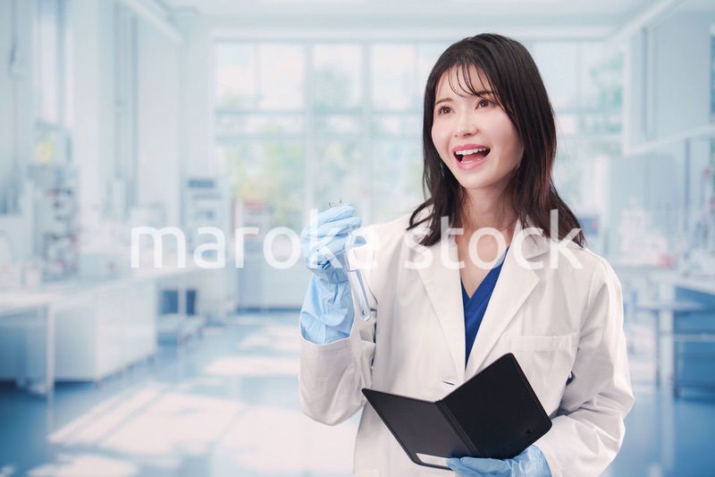 実験室で試験管の薬品を扱う若い女性