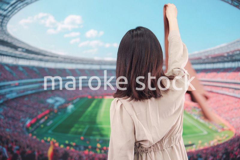 スタジアムで応援をする若い女性