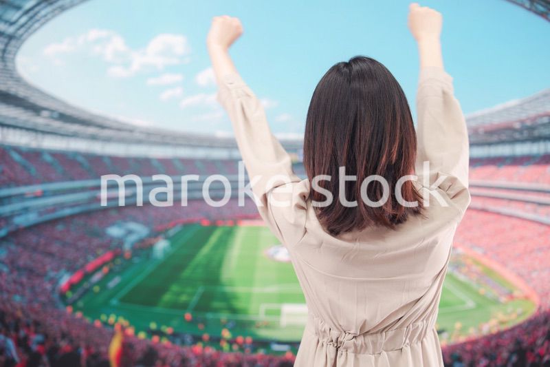 スタジアムで応援をする若い女性