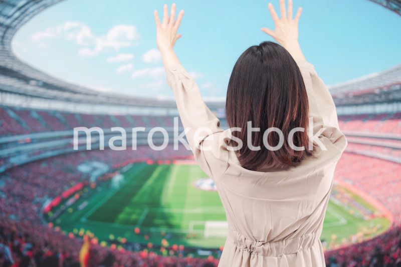 スタジアムで応援をする若い女性