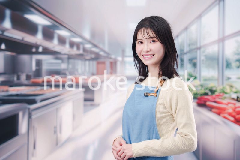 大きなキッチンで働く若い女性