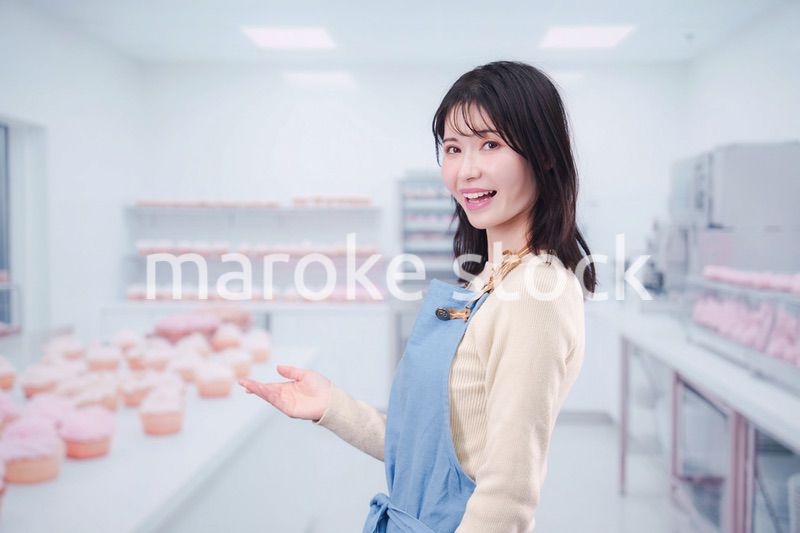 笑顔でお菓子作りをするパティシエの若い女性