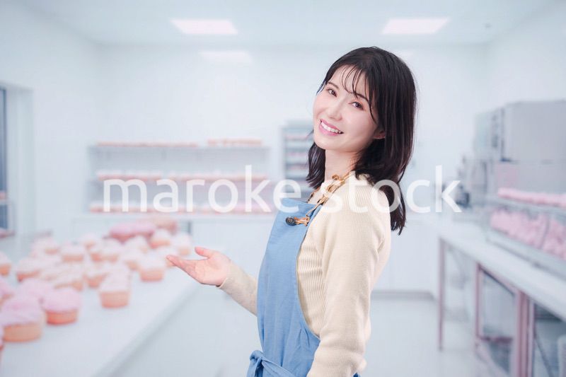 笑顔でお菓子作りをするパティシエの若い女性