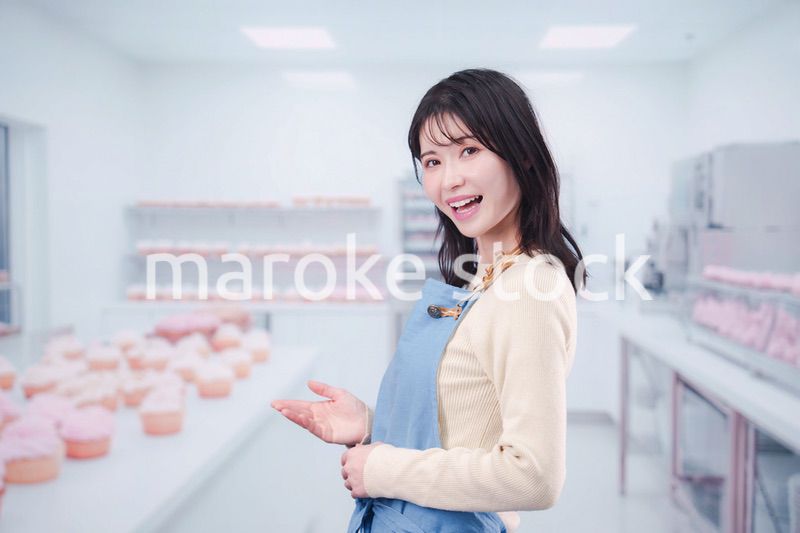 笑顔でお菓子作りをするパティシエの若い女性