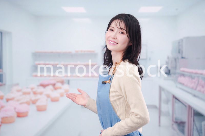 笑顔でお菓子作りをするパティシエの若い女性