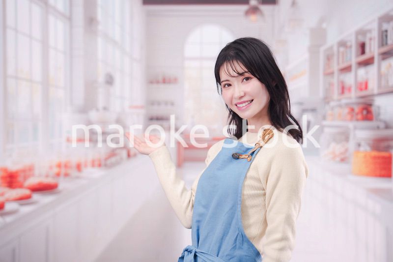 笑顔でお菓子作りをするパティシエの若い女性