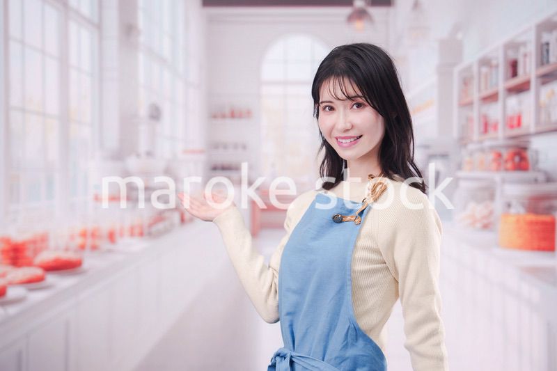 笑顔でお菓子作りをするパティシエの若い女性