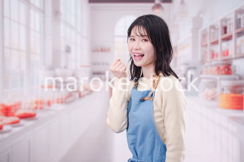 笑顔でお菓子作りをするパティシエの若い女性