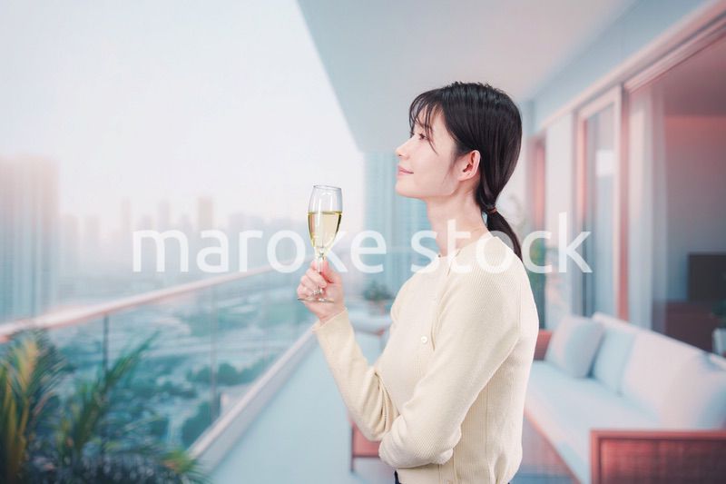 バルコニーでワインを愉しむ若い女性