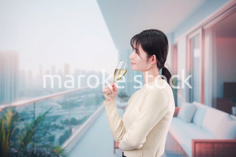バルコニーでワインを愉しむ若い女性