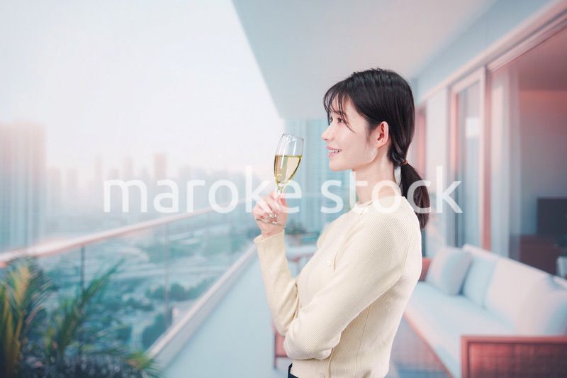 バルコニーでワインを愉しむ若い女性