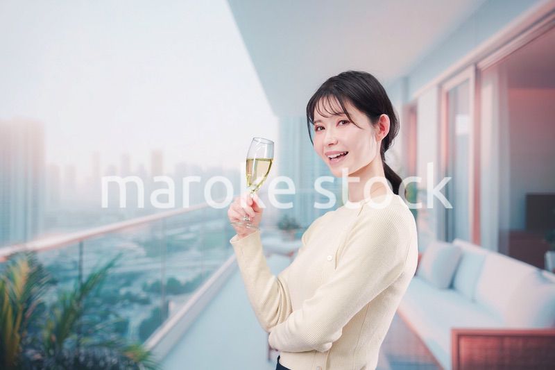 バルコニーでワインを愉しむ若い女性