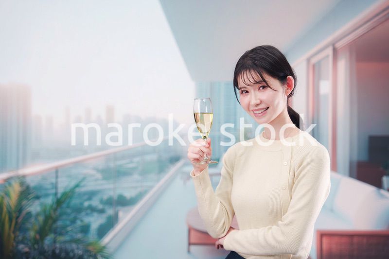 バルコニーでワインを愉しむ若い女性